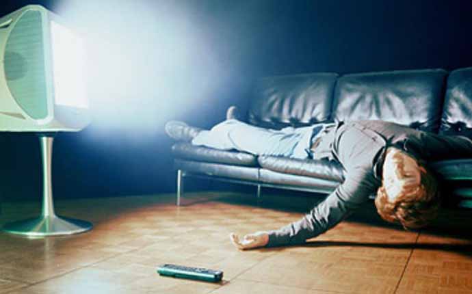 Man Lying on Sofa in Front of TV --- Image by © B. Bird/zefa/Corbis