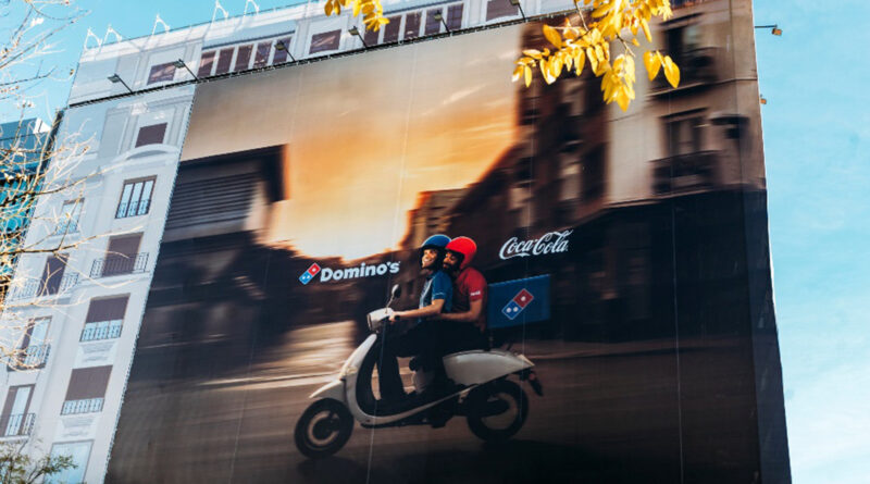 La metáfora resume en una sola escena la nueva alianza y el objetivo principal de la campaña: comunicar que la bebida de Coca-Cola pasa a incorporarse al pedido de pizza