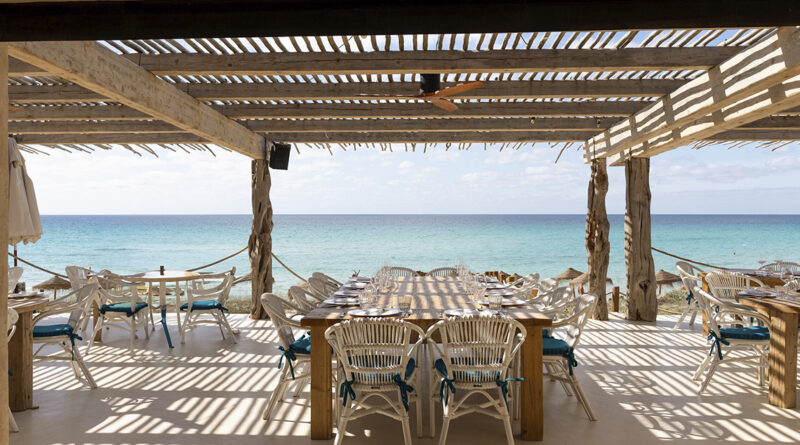 Situado en Es Arenals, en la costa de Migjorn, el establecimiento se presenta como un refugio de inspiración mediterránea y espíritu hedonista